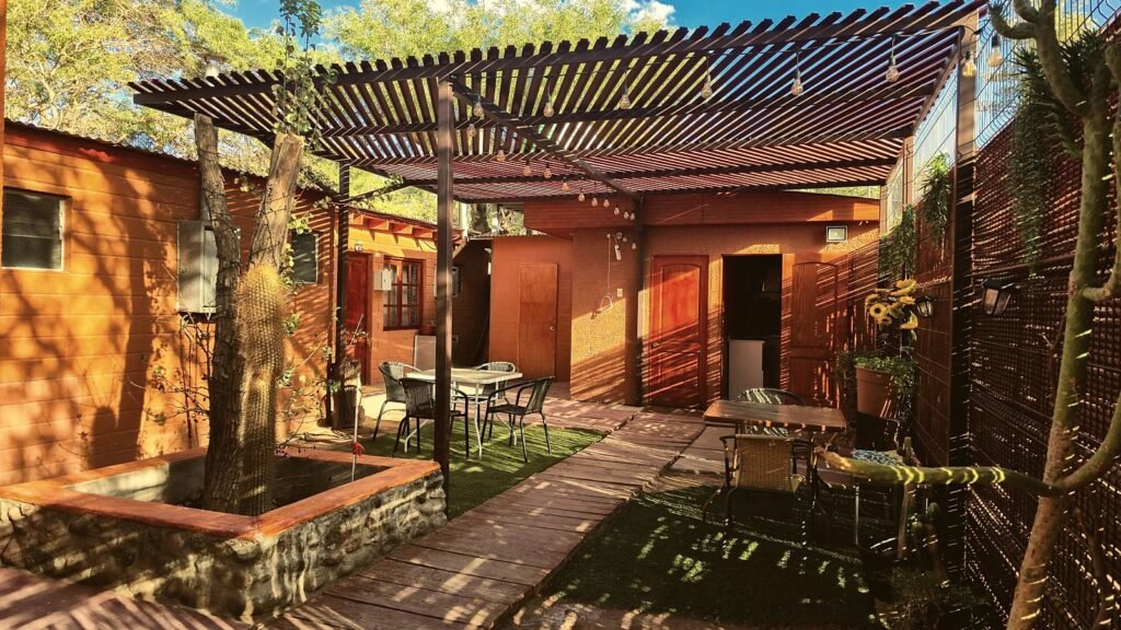 Patio con pérgola y mesas entre las habitaciones