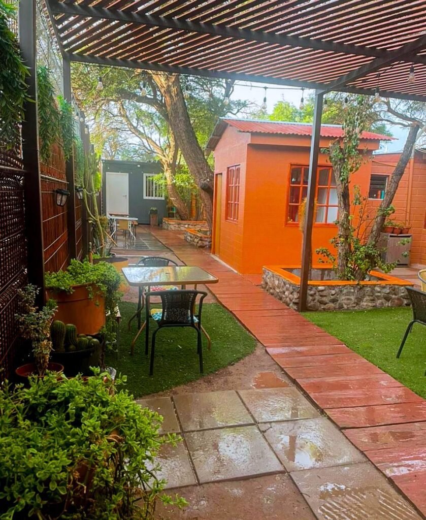 Patio con pérgola y habitaciones color adobe