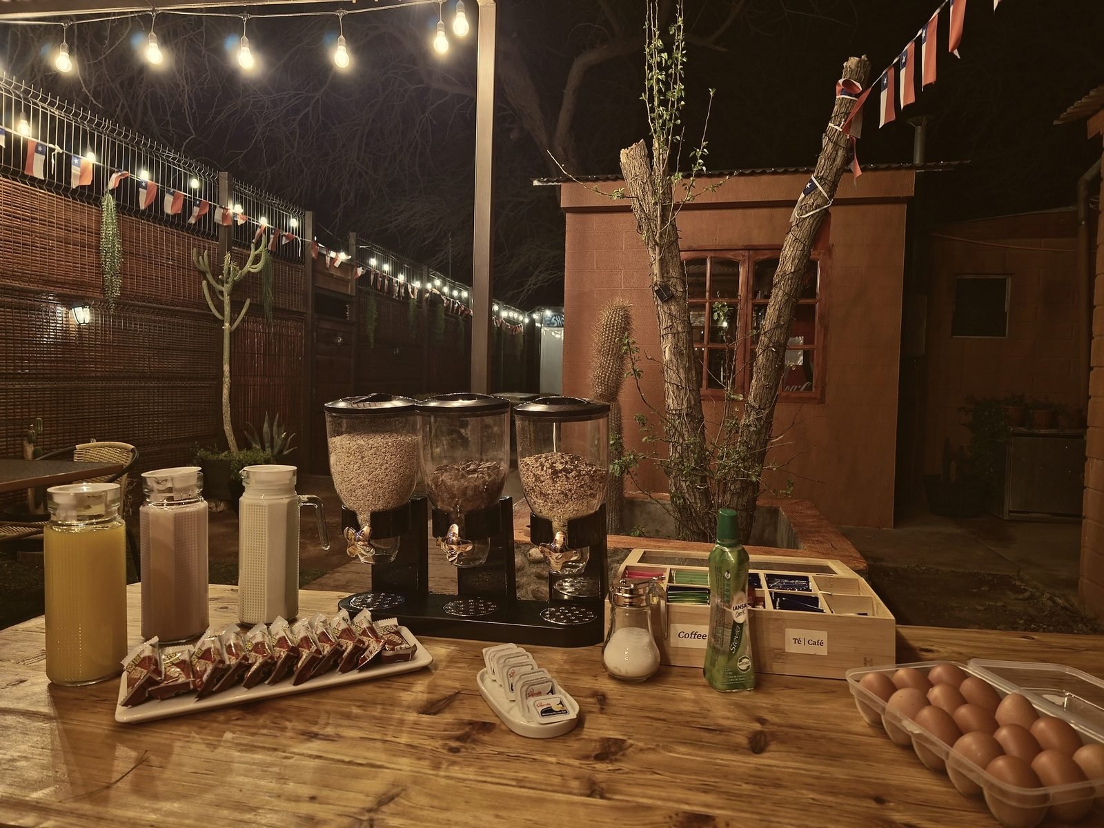 Desayuno autoservicio servido en el patio bajo las luces